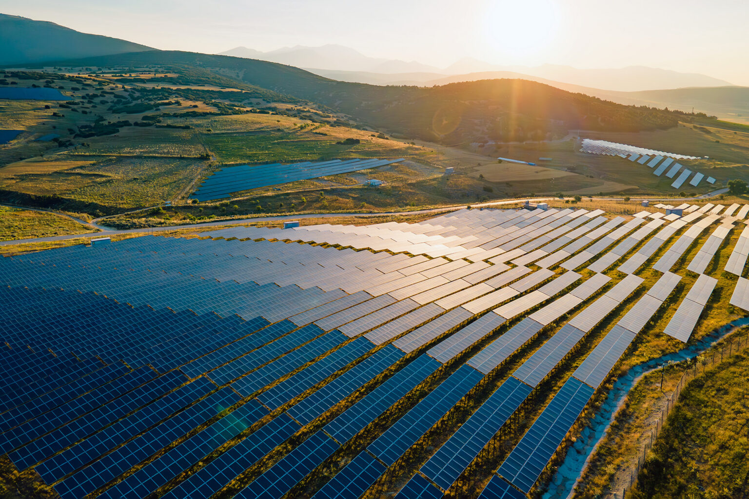 An array of solar panels on rolling hills